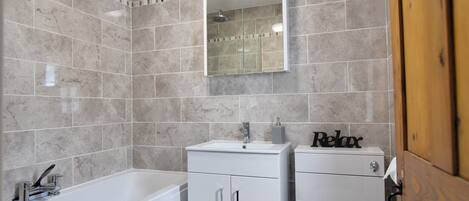 A bathroom with a bathtub, a sink, and a toilet.