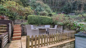A garden patio with wicker furniture and a wooden fence. - 44 Fernhill Heights (Bridport)