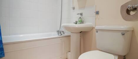 A bathroom with a bathtub, sink, and toilet.