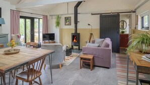 A spacious living area with a fireplace, seating, and a television.