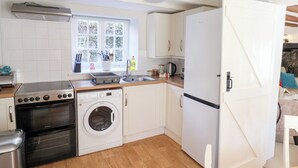 Una cocina compacta equipada con estufa, horno, lavadora y refrigerador.