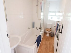 A bathroom with a bathtub, a toilet, and a shower. - The Gatehouse (Seaton)