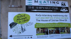 A sign for The Shipyard Pub, a museum, and a restaurant. - Little studio Sanjica in Pula, one person (Pula)