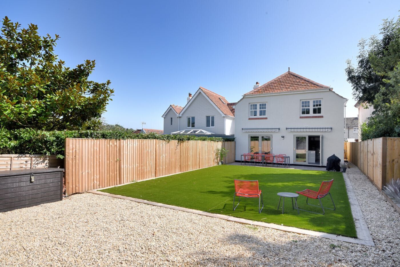 A two-story house with a well-maintained lawn and patio furniture.