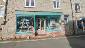 A building with a sign reading "Coombe Street Gallery" and a number "33" above the entrance. - Coombe Street Cottage (Lyme Regis)