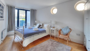 A bedroom with a bed, bedside tables, a chair, and a round ceiling light. - No. 2, 26 Broad Street (Lyme Regis)