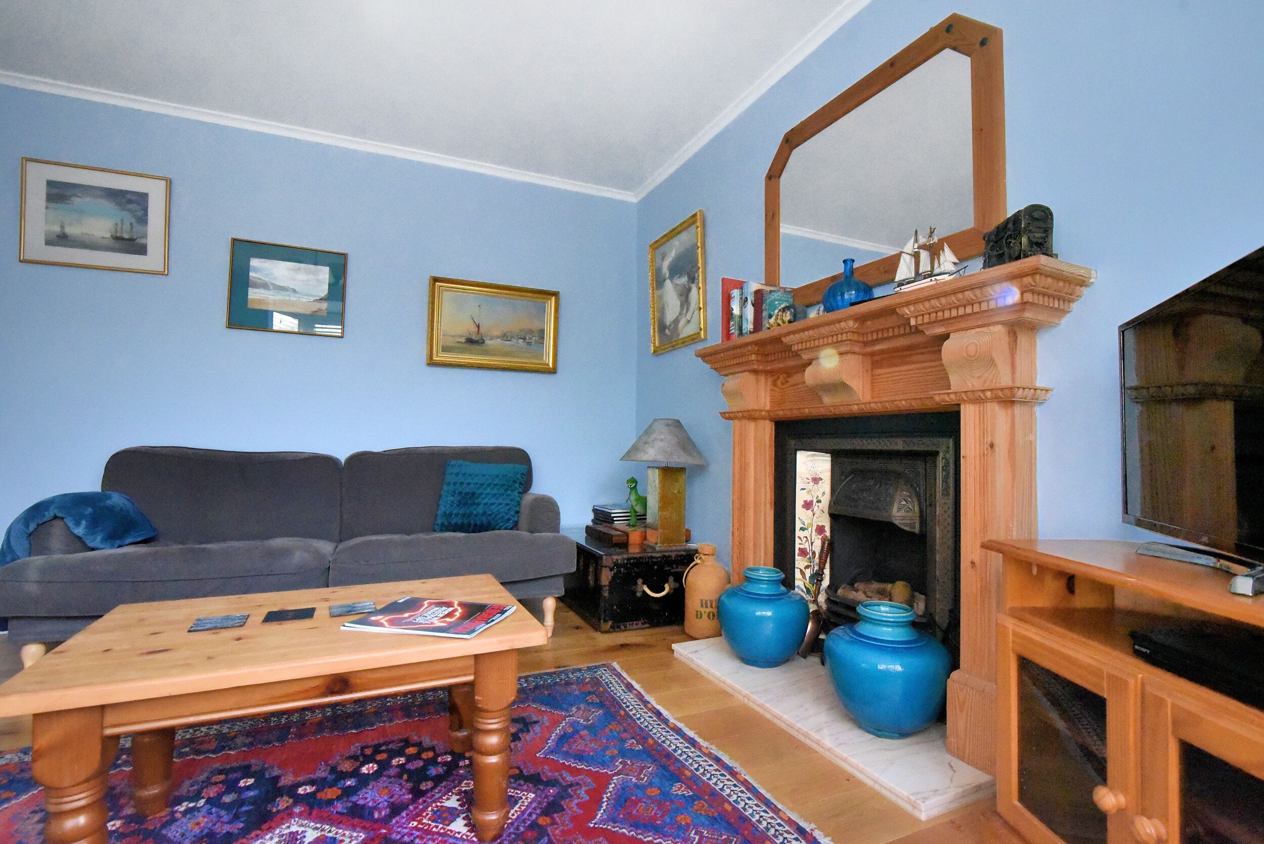 A living room with a fireplace, a sofa, a coffee table, and a television.