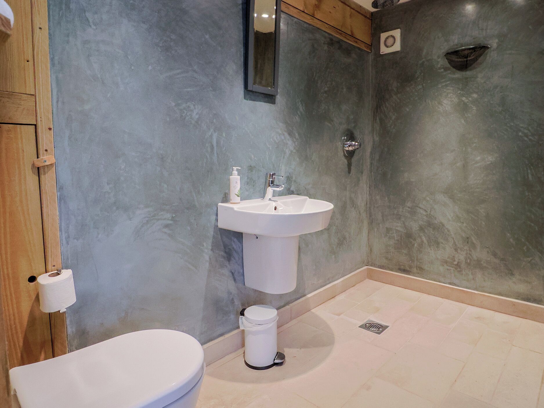 A bathroom with a toilet, sink, and a mirror.
