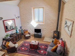 A cozy living room with a fireplace, a television, a comfortable sofa, and a patterned rug.