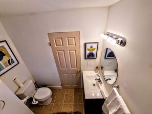 Ein kleines Badezimmer mit Toilette, Waschbecken und Spiegel.