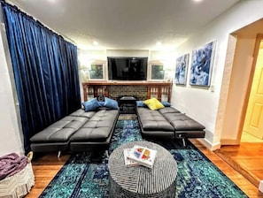 Relax in the living room with two sofas, a coffee table, and a large flat-screen TV above a fireplace.