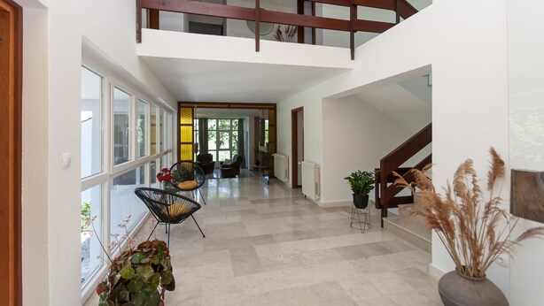 A spacious interior with a high ceiling, a wooden staircase, and a view of a dining area. - Villa Green Castle - Five bedroom villa with swimming pool (Zadvarje)