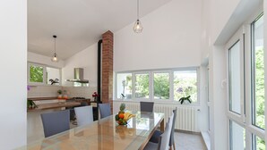 A modern kitchen with a glass dining table, a brick chimney, and large windows. - Villa Green Castle - Five bedroom villa with swimming pool (Zadvarje)