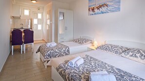Camera d'albergo con due letti, una scrivania e una sedia. Appeso al muro, c'è un quadro raffigurante un faro.