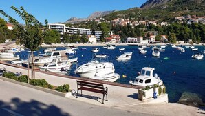 Un puerto deportivo con barcos amarrados, un banco y edificios al fondo.