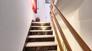 Una escalera de mármol con barandilla de madera.