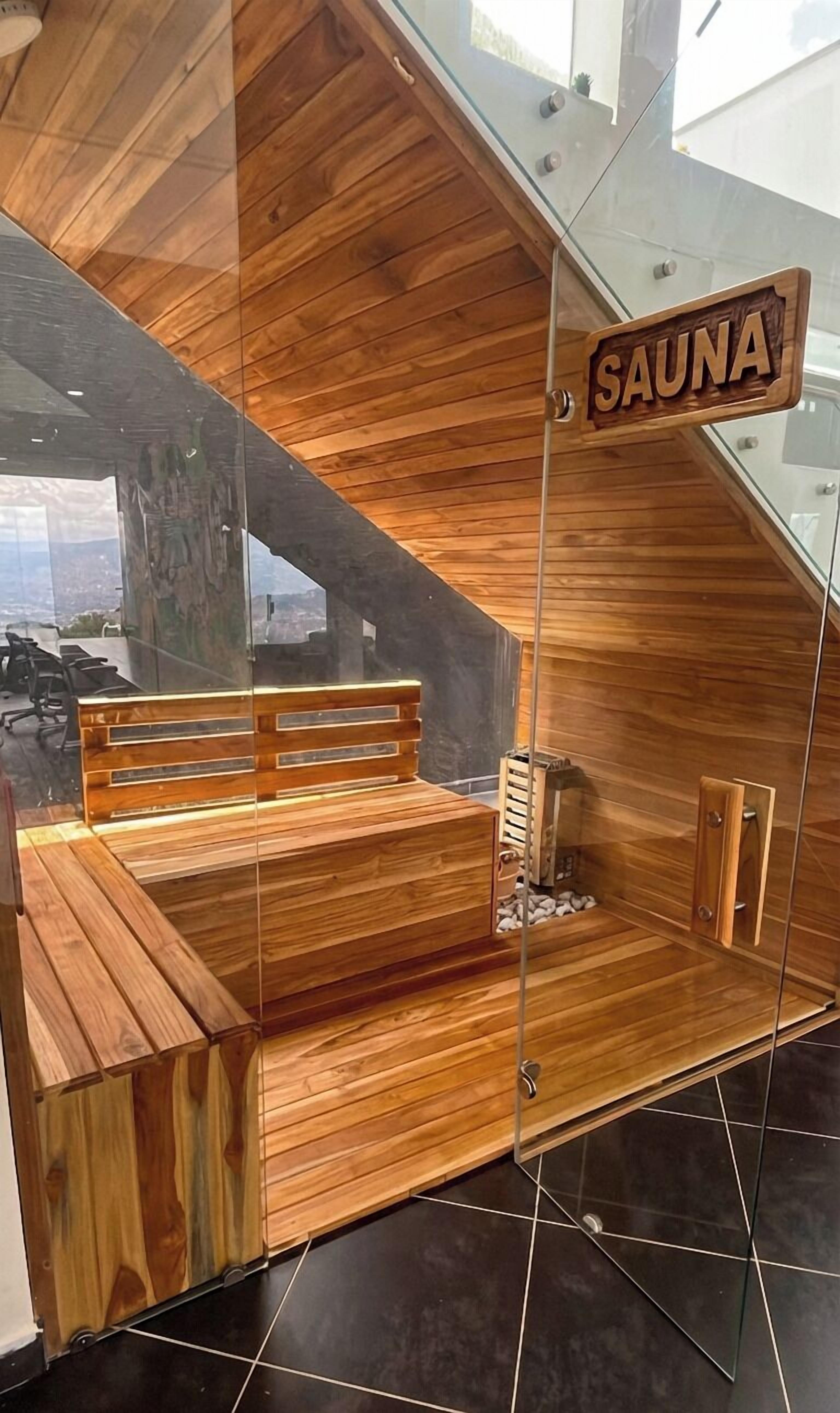 Una sauna con bancos de madera y un panel de vidrio.