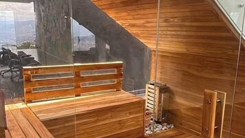 Una sauna con bancos de madera y un panel de vidrio.