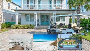 Ein zweistöckiges Haus mit Balkon, Golfmobil, Pool und Blick auf den Strand.