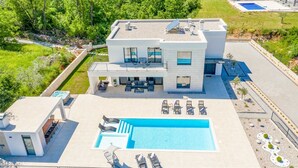 A modern two-story house with a large swimming pool, outdoor seating, and a well-maintained garden. - Villa Lagos - pool, spa, Jacuzzi and Red & Blue Lake by MyWaycation (Grubine)