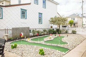 Un campo da minigolf con una casa sullo sfondo.