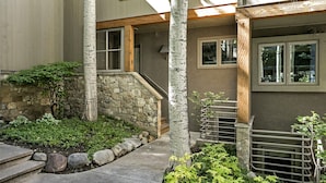 A residential building with a stone pathway, a wooden staircase, and a small garden area with various plants. - Villas of Aspen by Snowmass Vacations (Aspen)