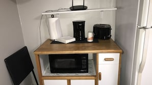 A compact kitchenette with a microwave, coffee maker, toaster, and a small refrigerator. - Glamping with a twist (Jacksonville)