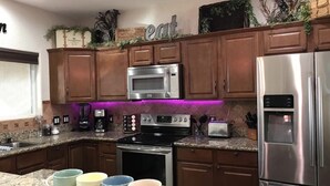 A kitchen with wooden cabinets, stainless steel appliances, and a granite countertop.