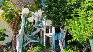 A modern building with a central staircase, surrounded by lush greenery and a clear blue sky. - Sunny apartment with sea view (Mogán)