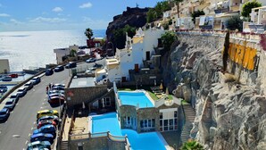 A coastal hotel with a swimming pool, a parking lot, and a view of the sea. - Sunny apartment with sea view (Mogán)