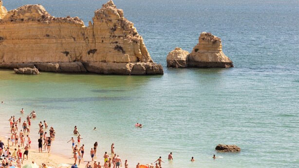 Une plage avec des formations rocheuses et une eau cristalline.
