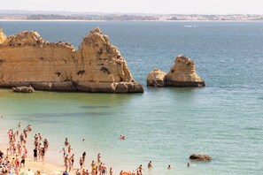 A beach with rocky formations and clear water.