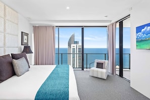Relax in a stylish room with a large bed, seating area, and stunning sea views.