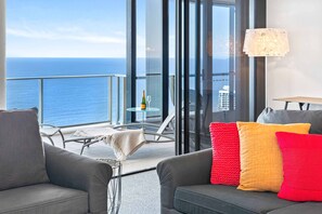 Enjoy ocean views from the large window, a comfortable seating area, and a balcony overlooking the sea.