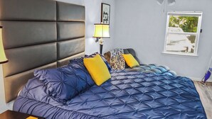 A bedroom with a large bed, a ceiling fan, a window, and a nightstand. - Luxurious beds, remodeled, very clean, quiet neighborhood, big backyard & tree!! (Denison)