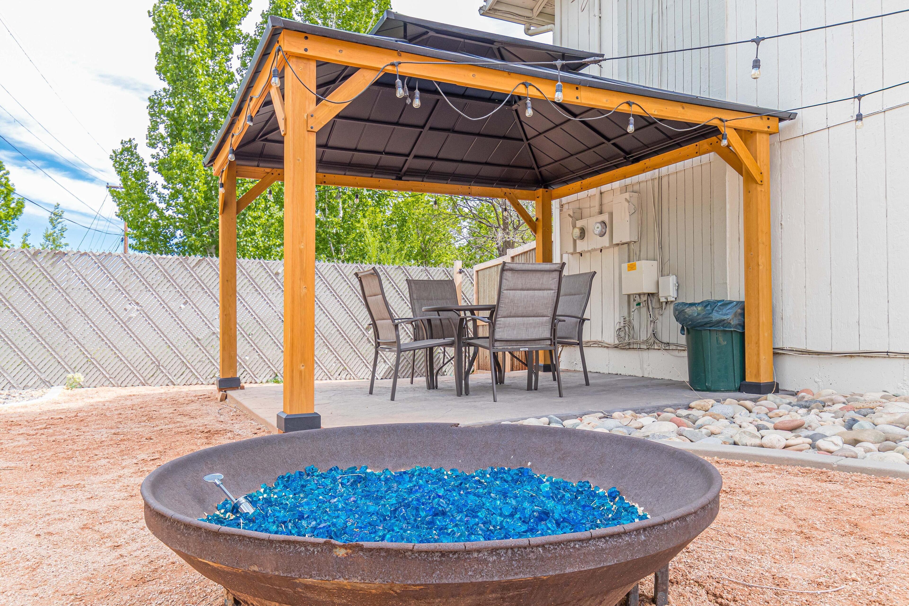 Eine Terrasse im Freien mit einer Pergola, einer Sitzgruppe und einem Feuerkorb.