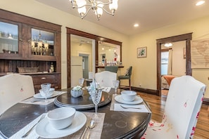 A dining area with a round table set for four, surrounded by wooden cabinets and a chandelier. - Cherry Blossom III: Dog Friendly Delight (Fruita)
