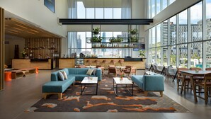 A spacious lobby with a high ceiling, large windows, and a modern seating area with sofas and tables. - Hyatt House Monterrey Valle-san Pedro (San Pedro Garza García)