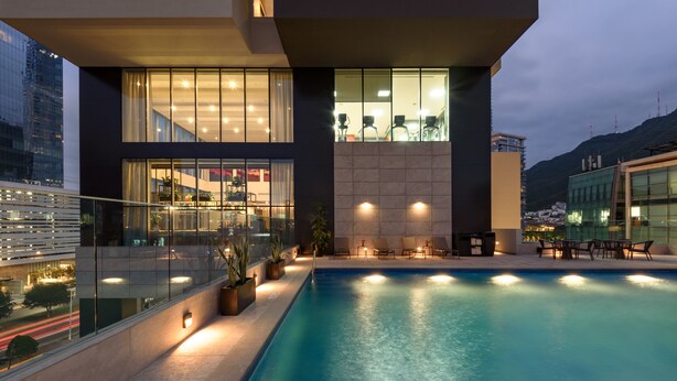 A modern building with a swimming pool, glass railings, and outdoor seating. - Hyatt House Monterrey Valle-san Pedro (San Pedro Garza García)