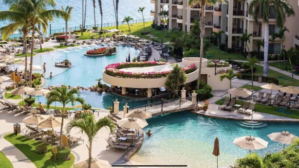A resort with a large central pool, multiple smaller pools, and a view of the ocean. - Located on the pristine medano beach (Cabo San Lucas)