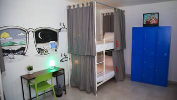 A bunk bed room with a desk, chair, and a blue locker.