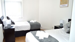 A hotel room with two beds, a map on the wall, and a window with blinds. - Beautiful Two-bed Apartment With Driveway Parking (Nottingham)