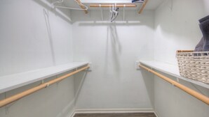 A narrow hallway with wooden handrails, a white wall, and a wooden floor.