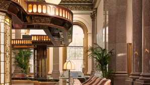 A luxurious lobby with a marble reception desk, a bar area with stools, and a patterned floor. - Gleneagles Townhouse (Edinburgh)