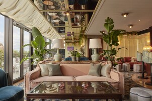 A spacious living area with a sofa, coffee table, and various plants.