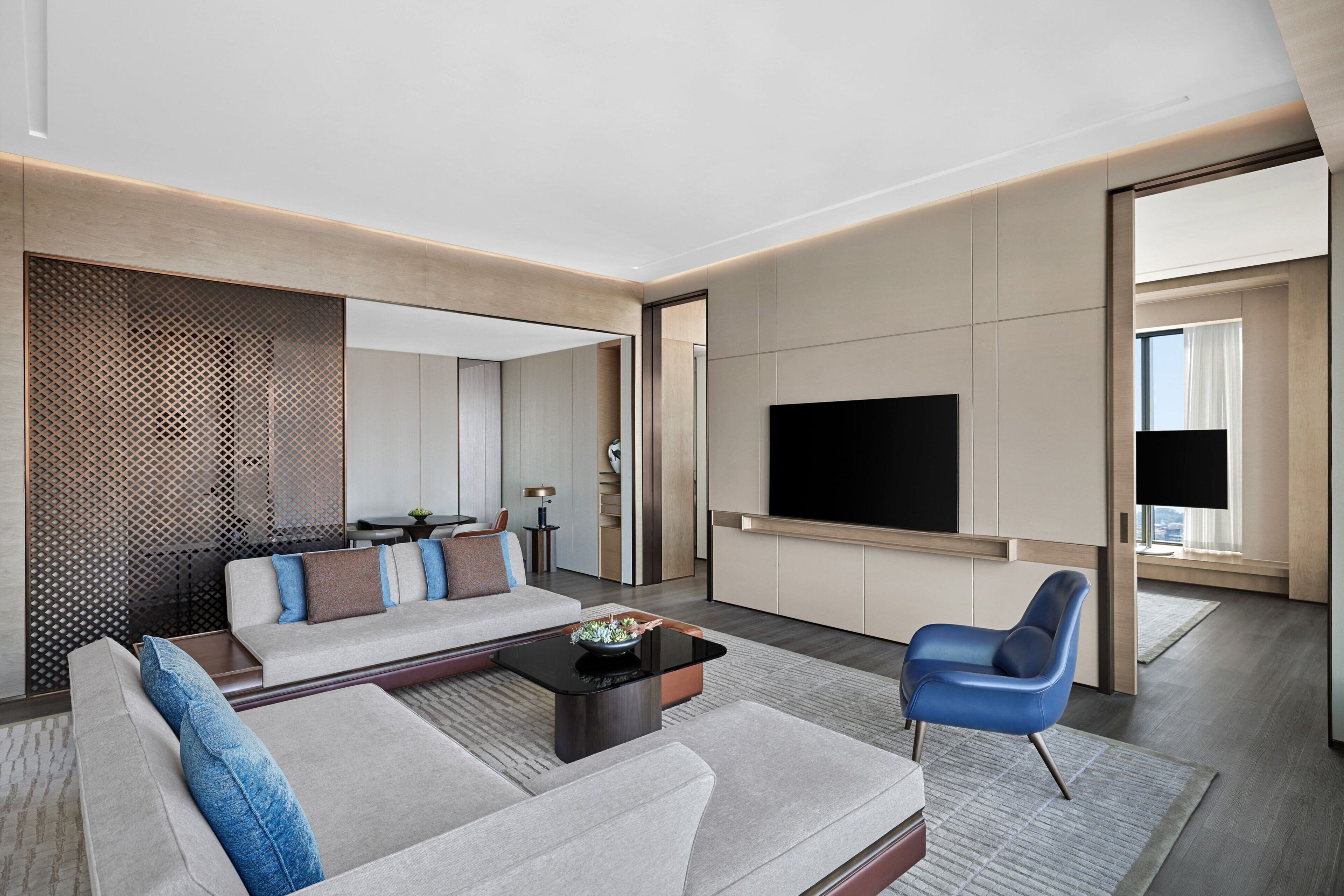 A modern living room with a sofa, a coffee table, and a TV.