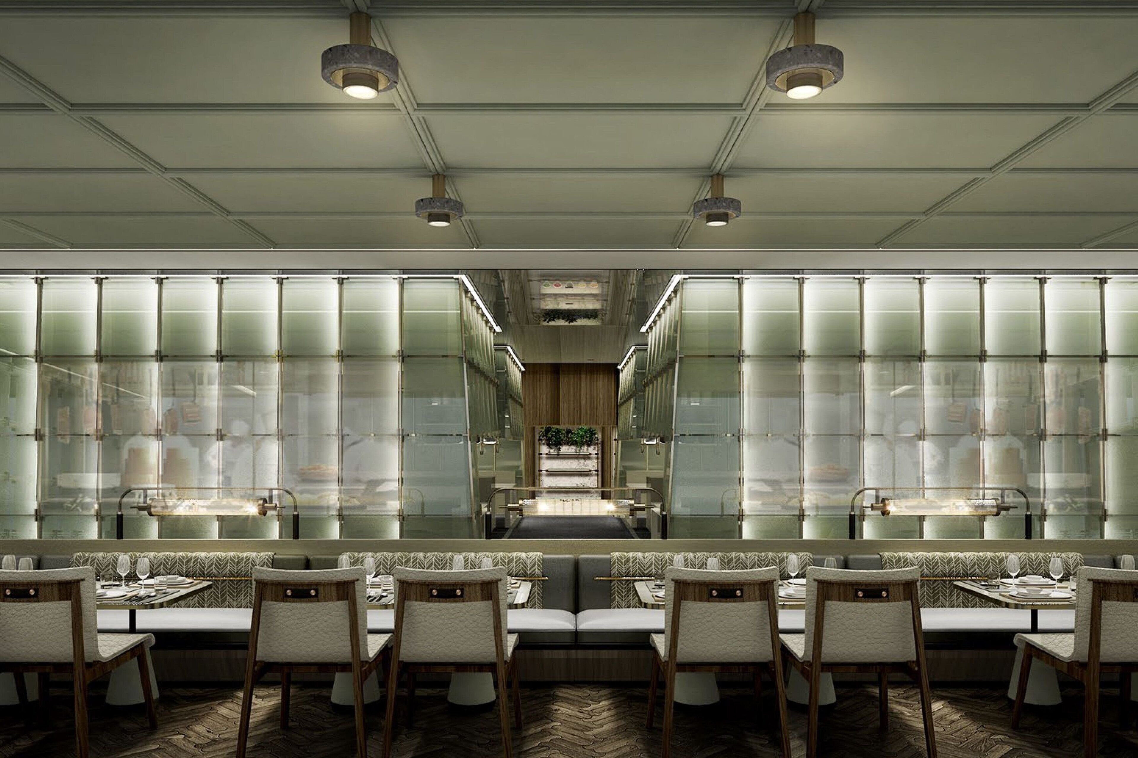 A modern restaurant with a long counter, cushioned seating, and a central walkway.