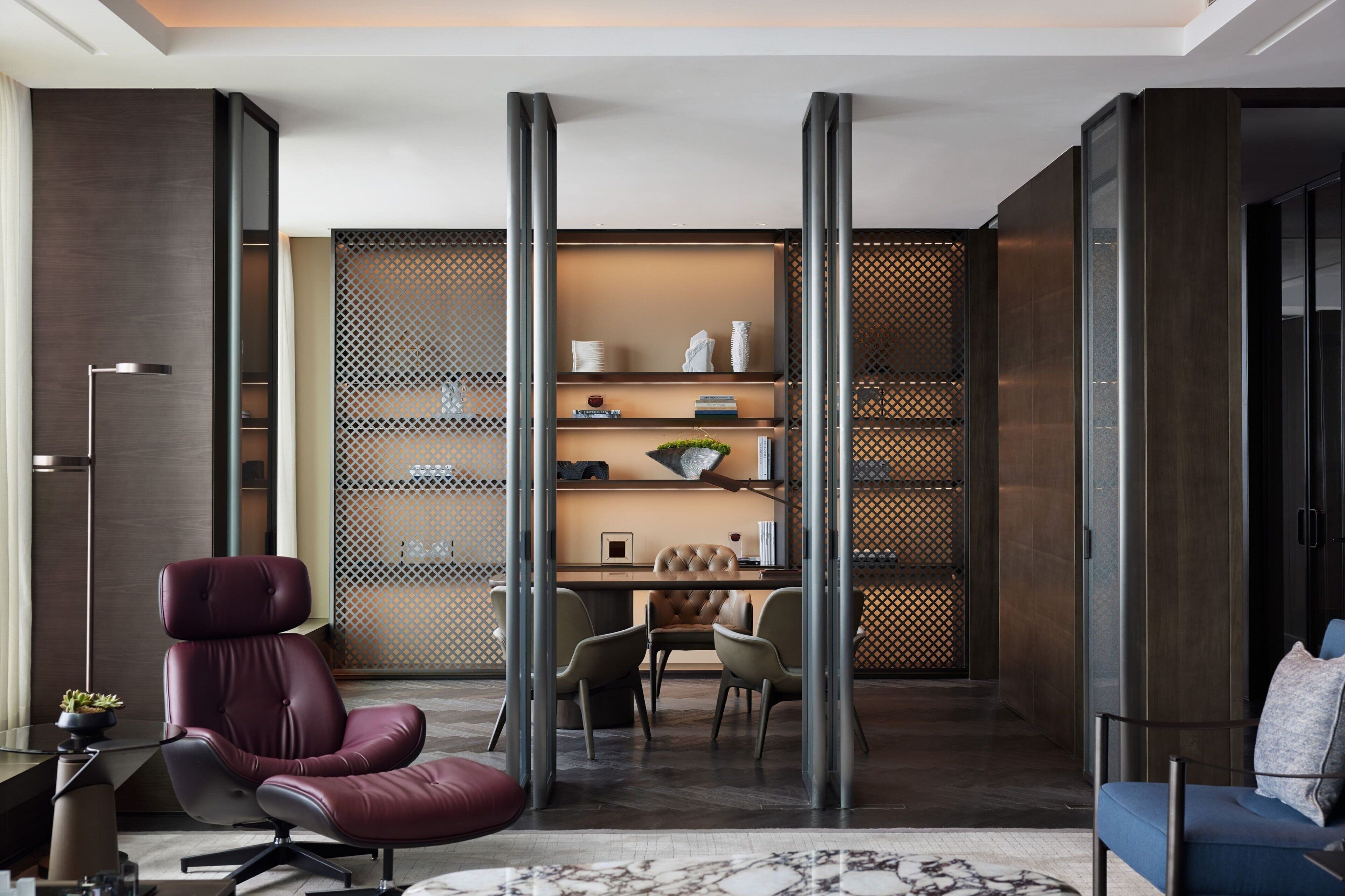 A modern office space with a leather chair, a desk, and a sofa.