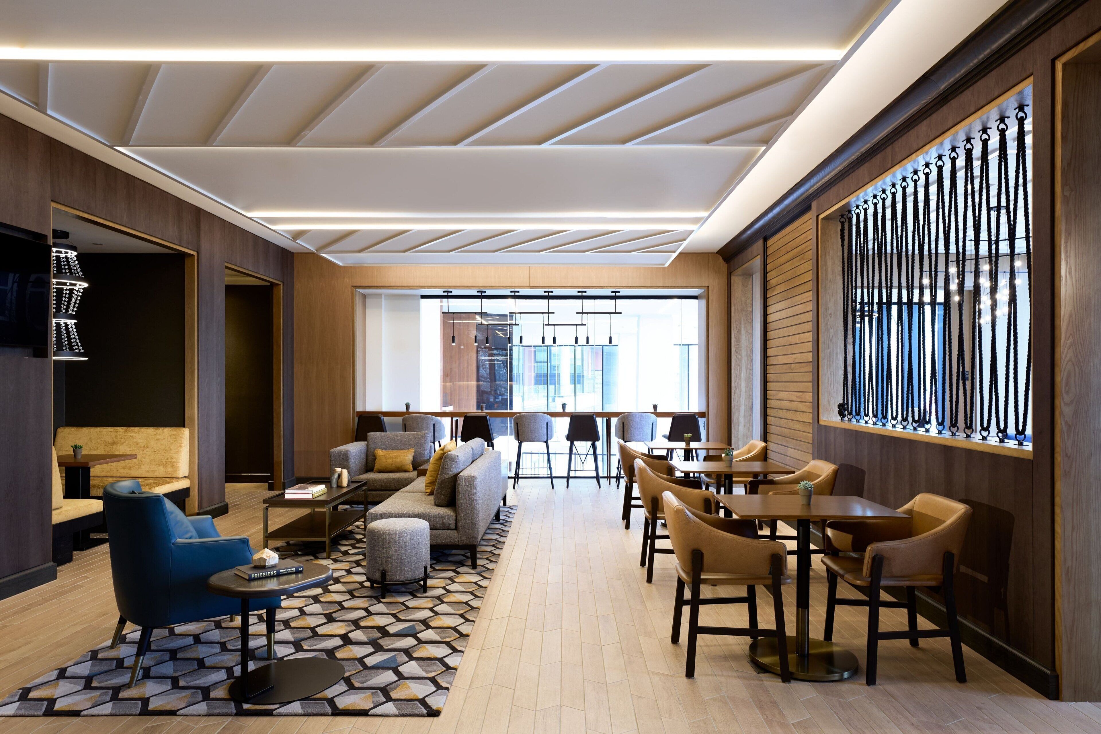 A modern lounge area with sofas, chairs, and tables arranged for socializing.