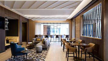 A modern lounge area with sofas, chairs, and tables arranged for socializing.